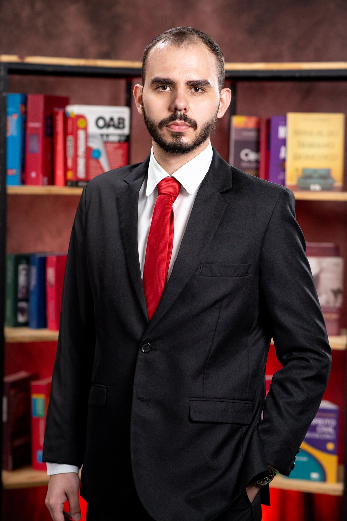 Fernando Araujo em pé diante de estante com livros de Direito